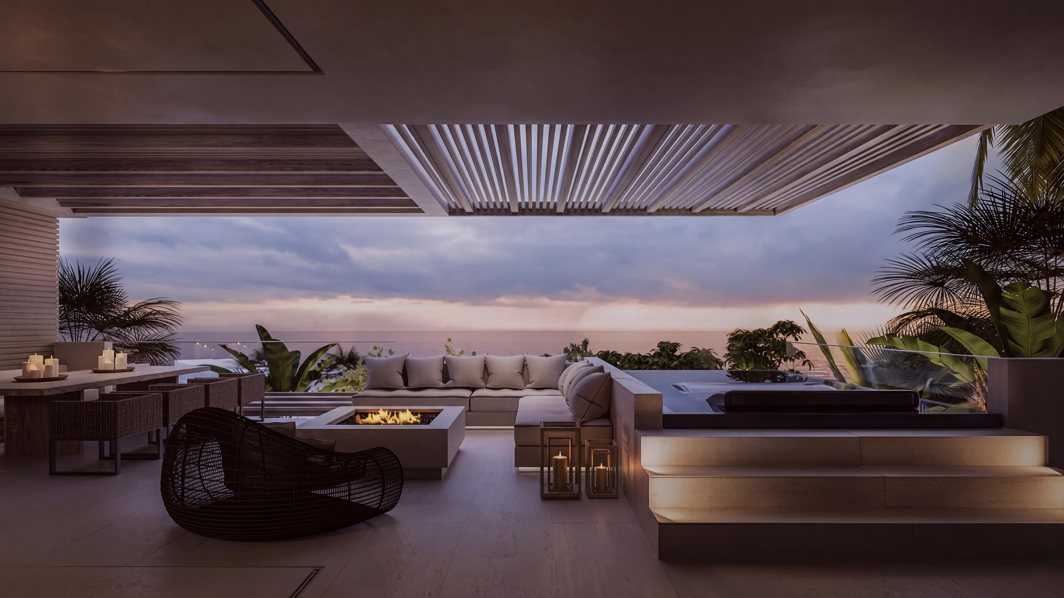 The Arc's terrace at dusk — the fire lit, the sea beyond